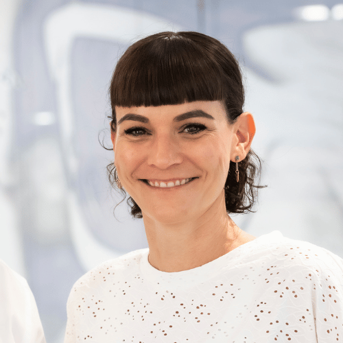 L&auml;chelnde Frau in wei&szlig;er Bluse im B&uuml;ro